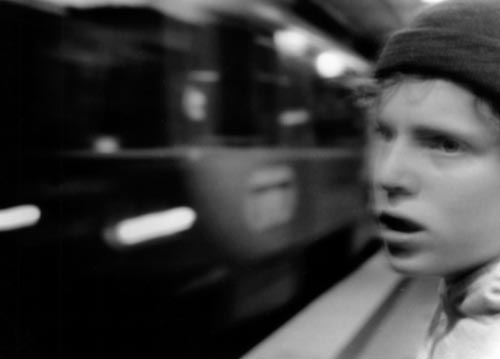 A boy watching a train go by.